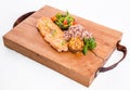 Golden grilled fish fillet with a side dish of rice and vegetables on a wooden board on a white background Royalty Free Stock Photo