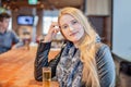Golden-haired blond girl sitting in a bar drinking an alcoholic drink. Royalty Free Stock Photo