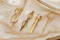 Golden hairpins on golden silk background, social media content.