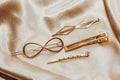 Golden hairpins on golden silk background, social media content.
