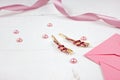 Golden hairpins with pink gemstone and pink ribbon on pink background