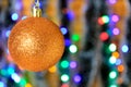 Golden hanging ball, christmas decoration with blurred lights background. Royalty Free Stock Photo