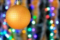 Golden hanging ball, christmas decoration with blurred lights background. Royalty Free Stock Photo