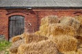 Golden haystack in front of an old brick building