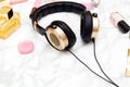 Golden headphones and cosmetics on a marble background. Feminine