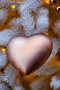 Golden heart on the Christmas tree and bokeh background of garland lights Royalty Free Stock Photo