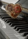 Golden heart shaped mesh case is filled with dried fruits stand on the Piano Keyboard Royalty Free Stock Photo