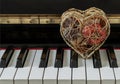 Golden heart shaped mesh case is filled with dried fruits stand on the Piano Keyboard Royalty Free Stock Photo