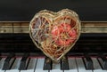 Golden heart shaped mesh case is filled with dried fruits stand on the Piano Keyboard Royalty Free Stock Photo