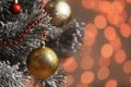Golden holiday bauble hanging on Christmas tree against blurred festive lights, closeup. Space for text Royalty Free Stock Photo