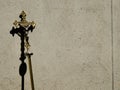 Golden holy processional cross leaning on a concrete Wall with shadow Royalty Free Stock Photo