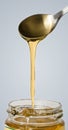 Golden honey dropping from spoon in jar Royalty Free Stock Photo