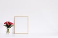 Golden horizontal frame and bouquet of rose flowers on white furniture, luxury home decor and design for mockup creation Royalty Free Stock Photo