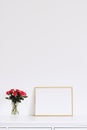 Golden horizontal frame and bouquet of rose flowers on white furniture, luxury home decor and design for mockup creation Royalty Free Stock Photo