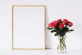 Golden horizontal frame and bouquet of rose flowers on white furniture, luxury home decor and design for mockup creation Royalty Free Stock Photo