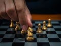 Golden horse, knight chess piece put by player's hand with gold pawn chess pieces on chessboard. Royalty Free Stock Photo