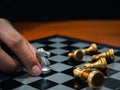 Golden horse, knight chess piece put by player's hand with silver pawn chess pieces, enemy on chessboard on dark background. Royalty Free Stock Photo