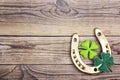 Golden horseshoe and clover leaves on old wooden boards. Space