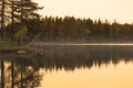 Golden hour beautiful reflection of island in misty lake. Royalty Free Stock Photo