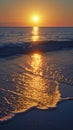 Golden sunset reflecting on ocean waves with smooth sandy beach in view Royalty Free Stock Photo