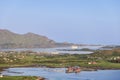 A cruise liner rests in a Norwegian fjord during golden hour, with rorbuer cabins along the shore Royalty Free Stock Photo