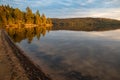 Golden hour on a lake surrounded by forest in autumn