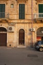 Golden Hour in Ostuni Typical Building with Old Wooden Door, Road, and Car