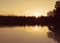 Golden hour sunset by a calm lake.