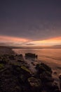 Golden hour sunset at Colwyn bay, North Wales. Warm sky and gentle waves along a rocky coastline Royalty Free Stock Photo