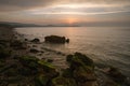 Golden hour sunset at Colwyn bay, North Wales. Warm sky and gentle waves along a rocky coastline Royalty Free Stock Photo