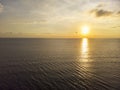 Golden hour sunset over the ocean with fluffy clouds and calm water Royalty Free Stock Photo