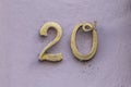 Golden house number twenty at pink wall