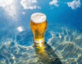 Glass of beer on the beach with crystal clear water and sun rays. Image created by artificial intelligence Royalty Free Stock Photo