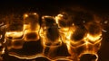 Golden ice cubes on black background closeup, transparent frozen melting ice shiny water drops, glowing yellow light, reflection