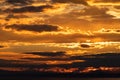 A golden sunset behind mountains and clouds Royalty Free Stock Photo