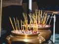 Golden incense burner and many incense sticks in a Thai temple