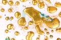 Golden ink drops on white paper background. Royalty Free Stock Photo