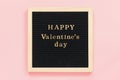 Golden inscription Happy Valentines day on black letter board, central composition on pink background. Template for