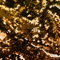 Golden iridescent sequins on fabric. Festive duotone background