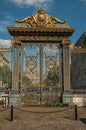 Golden iron gate and fence lavishly decorated under sunny blue sky in Paris. Royalty Free Stock Photo