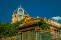 Golden iron gate lavishly decorated and dome under sunny blue sky in Paris. Royalty Free Stock Photo