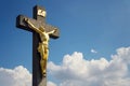 Golden Jesus Christ crucifixion statue, sunny summer day blue sky background
