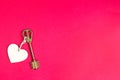 Golden key with wooden tag in the shape of a heart on a red background. Valentine`s day, Declaration of love, copy space. Open, Royalty Free Stock Photo