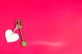 Golden key with wooden tag in the shape of a heart on a red background. Valentine`s day, Declaration of love, copy space. Open, Royalty Free Stock Photo