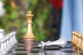 A golden king chess piece standing on a stack of dollar coins and a silver king chess piece failing to beg for mercy on a chess bo Royalty Free Stock Photo