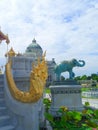 Golden King if Naga and Elephant sculpture at Ruen Yod Barom Mungkalanusaranee pavilion under bright blue sky