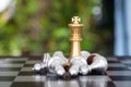 The golden king pawn in chess is besieged by a pile of silver pawns