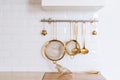 Golden kitchen utensils for cooking on a white wall with copy space Royalty Free Stock Photo