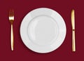 Golden knife, fork and white plate on red Royalty Free Stock Photo