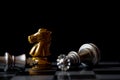 Golden knight stand as last winner over silver king on chess board. Black background for Bankruptcy concept